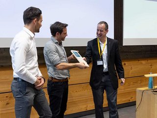 Jurypräsident Gregor Haab (r.) übergibt den Award an Mario Marty (l.) und Thomas Fuchs (M.) von der B3 Kolb AG.
